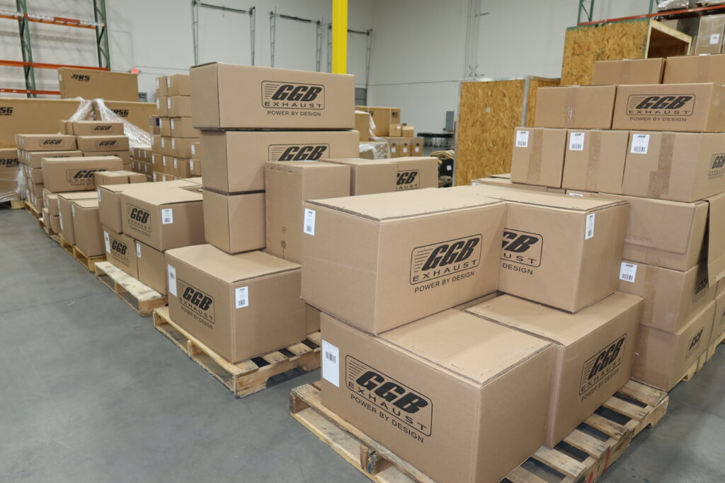Pallets of Boxes of Aftermarket snowmobile exhaust systems being shipped through a global freight transportation and fulfillment supply chain.