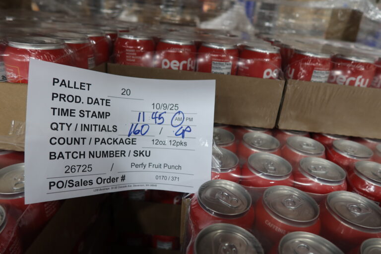 cans of drinks and a shipping manifest on a pallet.