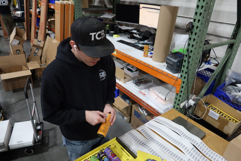 A TCB worker prepping cans of soda for Beverage Fulfillment