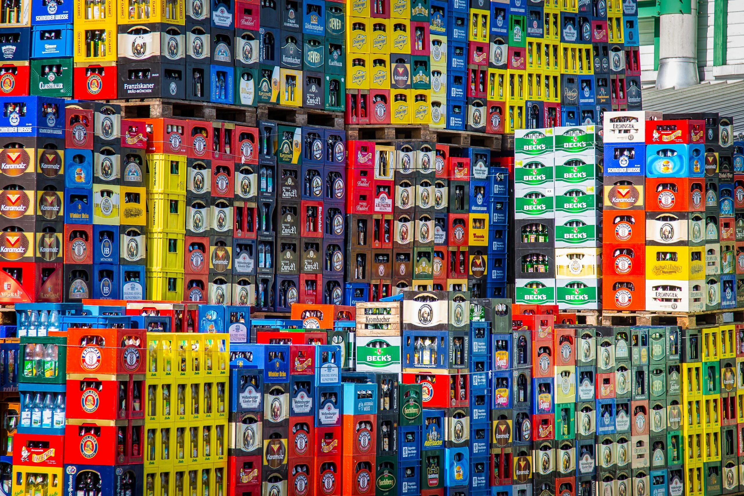 A vibrant display of beer cratesA vibrant display of beer crates stacked in a warehouse, showcasing various brands ready for beverage 3pl.