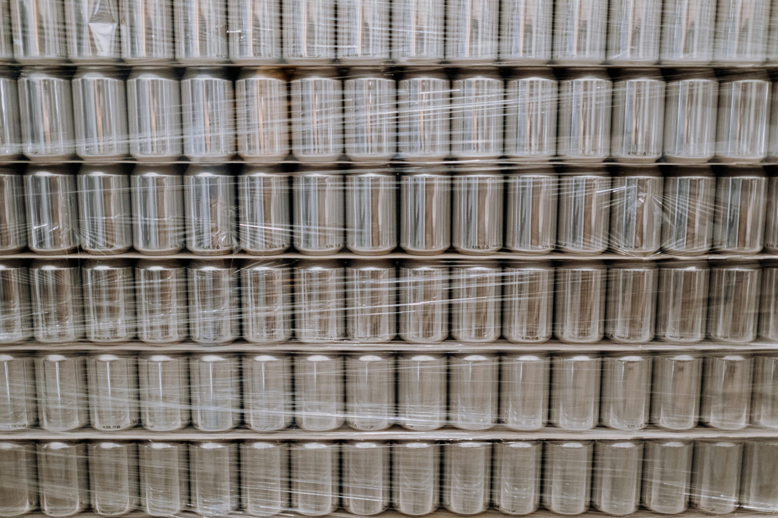 Pallets of empty cans wrapped in plastic film, ready for effective an effective beverage fulfillment pipeline.